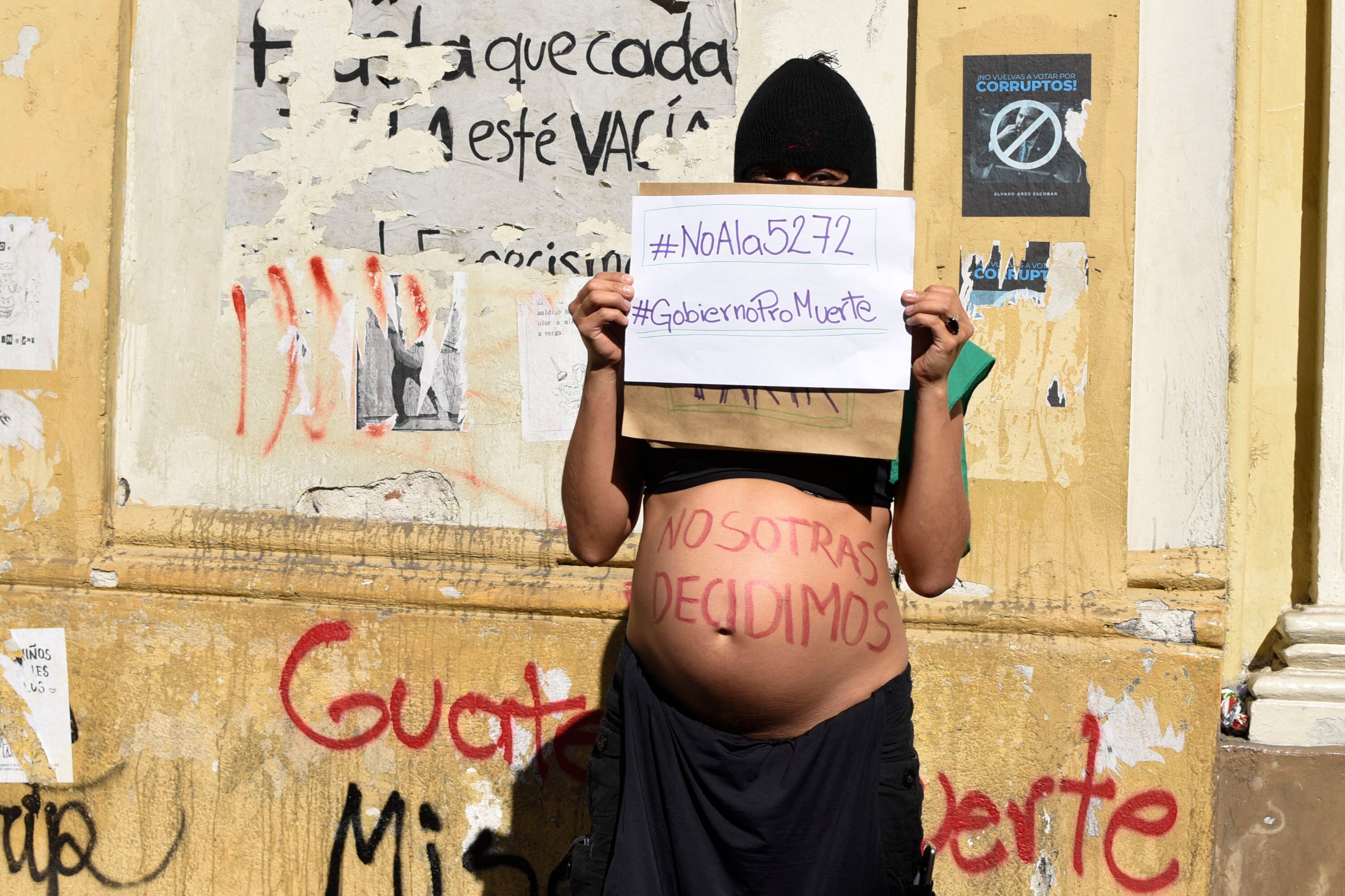 Personas protestan por el aborto y los derechos LGBTQ fuera del Congreso de Guatemala en Ciudad de Guatemala el 15 de marzo de 2022. (Foto por Orlando ESTRADA / AFP)